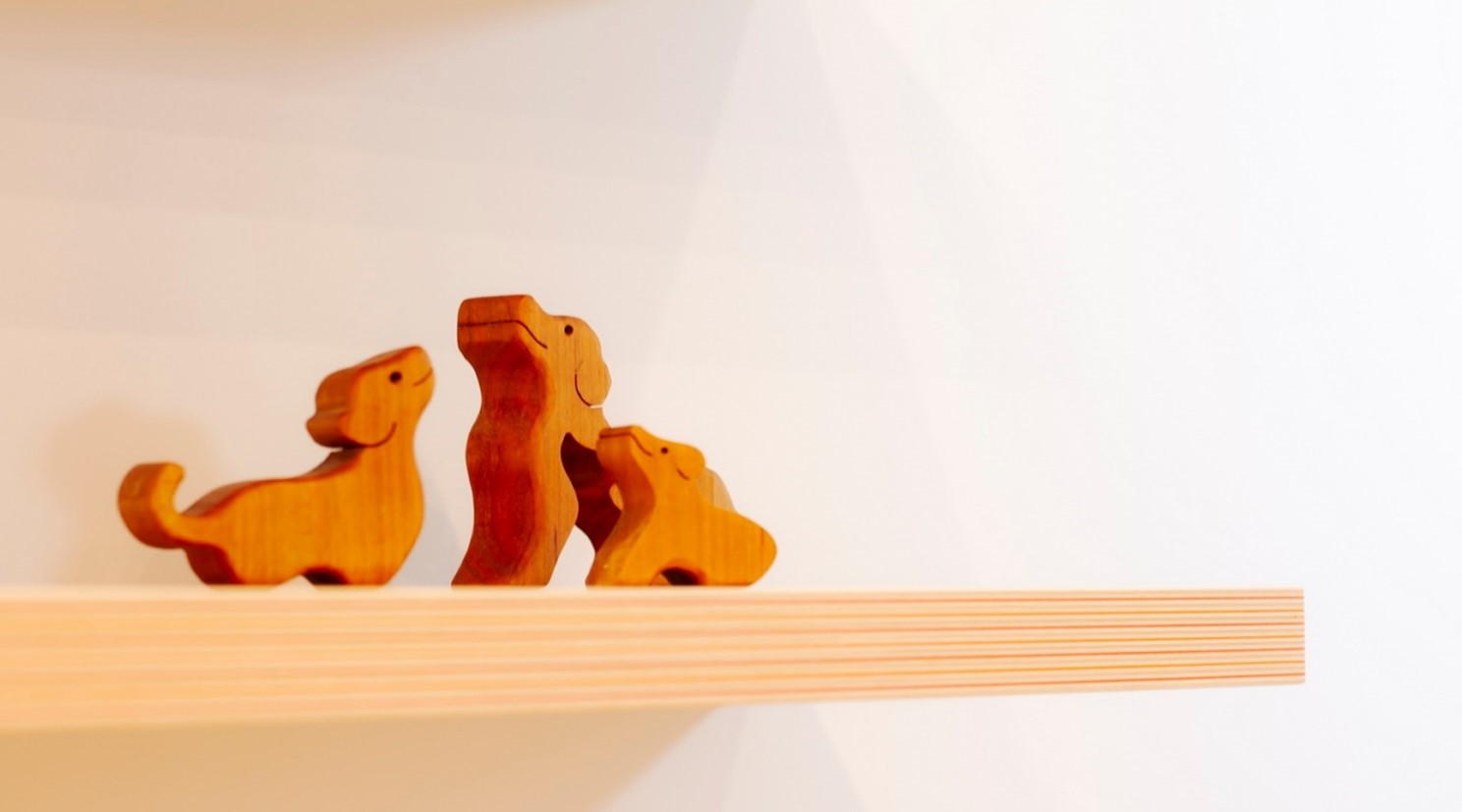 木彫りの犬が3匹寄り添っている画像